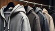© Designpro - Row of stylish grey shades hoodies hanging on  hangers in clothing store. casual wear & fashion trendy comfortable apparel retail