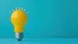 © Sasiwan - A bright yellow light bulb stands on a turquoise background, symbolizing creativity, innovation, and new ideas.