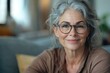 © Isuru - Happy elderly woman poses for headshot in living room.