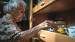 © ADD PHOTO - Elderly Woman Organizing Items in Wooden Cabinet
