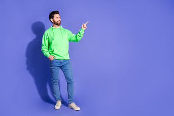 Poster - Full size photo of pretty young male look point empty space wear trendy green outfit isolated on purple color background