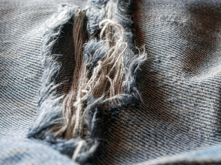 Wall Mural - Close-up of worn torn jeans blue denim texture background, jean fashion style, macro