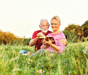 Wall Mural - woman man outdoor senior couple happy lifestyle retirement together smiling love reading nature book