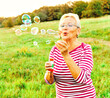 © Lumos sp - woman outdoor senior elderly happy fun retirement vitality bubble soap blowing active old nature mature