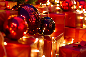 Wall Mural - christmas decor with red toy balls and red gift boxes, lights bokeh in the background, merry christm