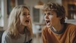 © Azis Stock - A young boy and girl are arguing while sitting on a couch.  They are both yelling and looking angry.