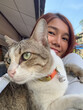 © Suthida - Vertical photo of Thai asian woman holding and taking selfie with her cat, pet lover, good friend.