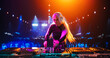 © Gorodenkoff - Stylish Girl Performing at a DJ Concert Live on Stage. Talented Music Producer Dancing, Mixing Energetic Dance Hits on Turntables. Young Beautiful Female Engaging with the Crowd