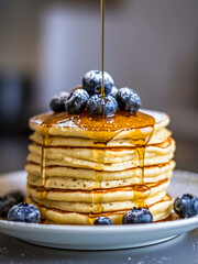 Poster - Pancakes with syrup sprinkled with fresh blueberries and powdered sugar on a white plate