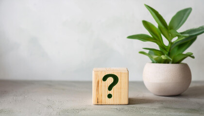 Fototapete - Wooden block with question mark, green plants on backdrop. FAQ and QA. Problem solution.