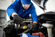 © zphoto83 - A mechanic repairs an engine in a workshop during the day, using a ratchet tool for precise adjustments and maintaining vehicle performance