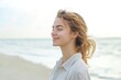 © Alla - A woman stands alone on a sandy beach next to the vast ocean, great for travel or lifestyle images