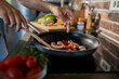 © Geber86 - Young woman cooking healthy vegetables in modern kitchen