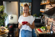 © Geber86 - Young woman filming cooking tutorial in kitchen with fresh vegetables and eggs