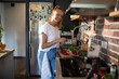 © Geber86 - Young woman filming cooking tutorial in kitchen with fresh vegetables and eggs