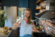 © Geber86 - Young woman filming cooking tutorial in kitchen with fresh vegetables and eggs