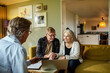 © Marko Geber - Senior couple talking to financial advisor at home