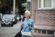 © Davor - Active senior woman using smartphone while leaving gym