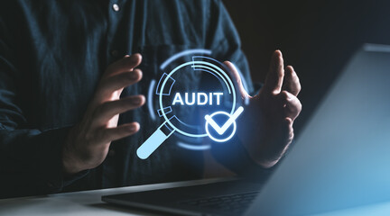 Poster - Hands holding digital audit icon with checkmark, blue glow, laptop background. Concept of quality assurance and approval