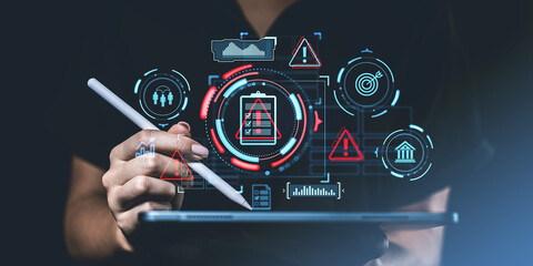 Poster - Hand holding a stylus over a tablet with futuristic risk management icons such as warning signs, data charts, and safety symbols on a dark background.