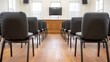 © Creative Workflow. - Empty courtroom with rows of chairs facing judge's bench and TV.