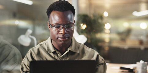 Poster - Black man, office and laptop with reading, thinking or planning in working late at night on project. Male person, technology and concentration as web designer in digital agency for online navigation