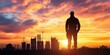 © Surasak-Art - Silhouette of a construction worker against a sunset sky with city skyline