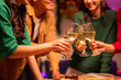 © Wasana - Three people are holding up their wine glasses and toasting to each other