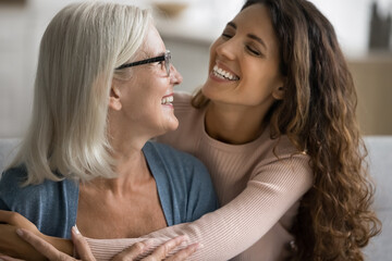 Wall Mural - affectionate and joyful moment between older mother and her grown up loving daughter, close up. mult