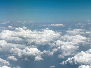 Wall Mural - Blue sky over clouds, View out of an airplane window.