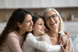 © fizkes - Three generational women embracing, smiling spending pleasant time together, celebrate life event, Happy Mother Day at home, close up. Family unity, love, deep connection between different generations