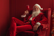 © ALL YOU NEED studio - fancy atrcative stylish cool santa claus smiling , wearing red velvet classic suit chilling sitting on the rich armchair with a red coctail. rich fabulous restorane , Festive holiday dinner, Christmas