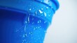 © sasiprapa - A close-up view of a blue surface with water droplets and a stream of water dripping down the side.