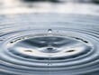 © Phetthanousack - A small clear water droplet is suspended high above the surface of a lake with circular waves gently lapping at its edges, circular waves, water movement