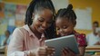 © Johannes - Happy mature female teacher educator helping African American junior school kid girl student using digital tablet computer education program app technology during elementary class lesson in classroom
