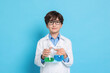 © New Africa - Boy with glassware pretending to be scientist on light blue background. Dreaming of future profession