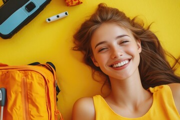 Wall Mural - A woman lies on the ground beside a bright yellow suitcase, possibly lost or stranded