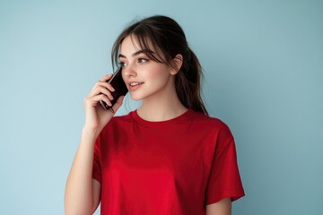 Poster - A woman wearing a red shirt is using her cell phone outdoors