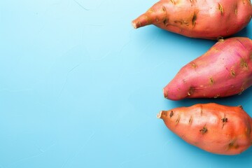 Poster - Three sweet potatoes arranged on a blue surface