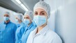 © Riko - Group of healthcare workers wearing protective masks and hairnets in a sterile environment.