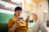 Woman making online payment with credit card and smartphone at home