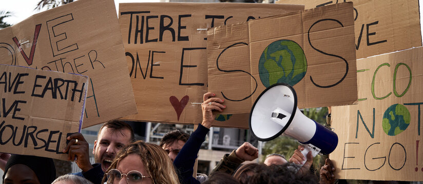 Close-up of global warming banners, activist people protesting for the earth and warning about environmental problems, crisis demonstration with placards calling for awareness.