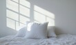© Vergiliy - Soft white pillows on bed with sunlight shadows