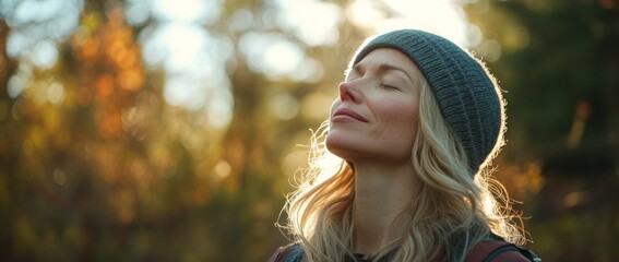 A woman wearing a hat is smiling and looking up at the sky