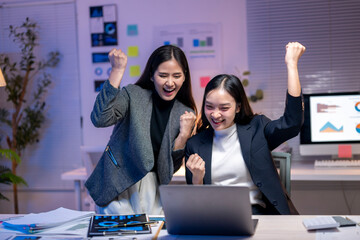 Wall Mural - Two women are celebrating in front of a computer monitor