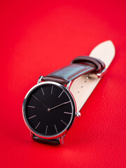 close-up of brown leather men's watch in minimalist style on red background