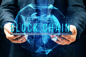 Poster - Businessman holding a tablet with a holographic blockchain world map on a digital background. Concept of blockchain technology.
