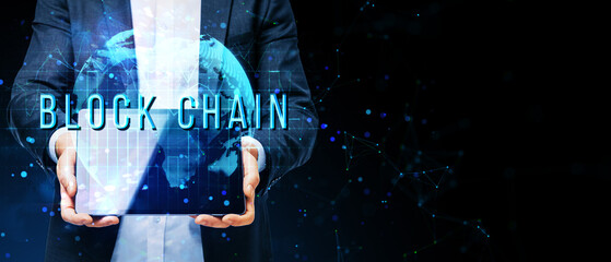 Poster - Businessperson holding a holographic globe with the word BLOCKCHAIN on a futuristic digital background.