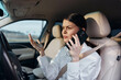 © SHOTPRIME STUDIO - Woman driving car, hands on steering wheel, talking on cell phone, looking at rear view mirror