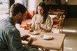 © BGStock72 - A joyful couple enjoys coffee and pastries in a cozy cafe during a sunny afternoon